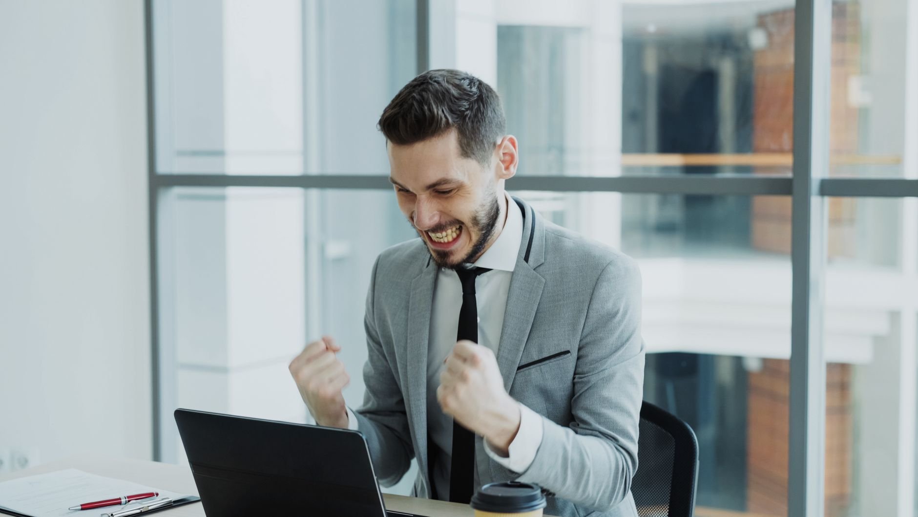 Man celebrating job offer success at laptop